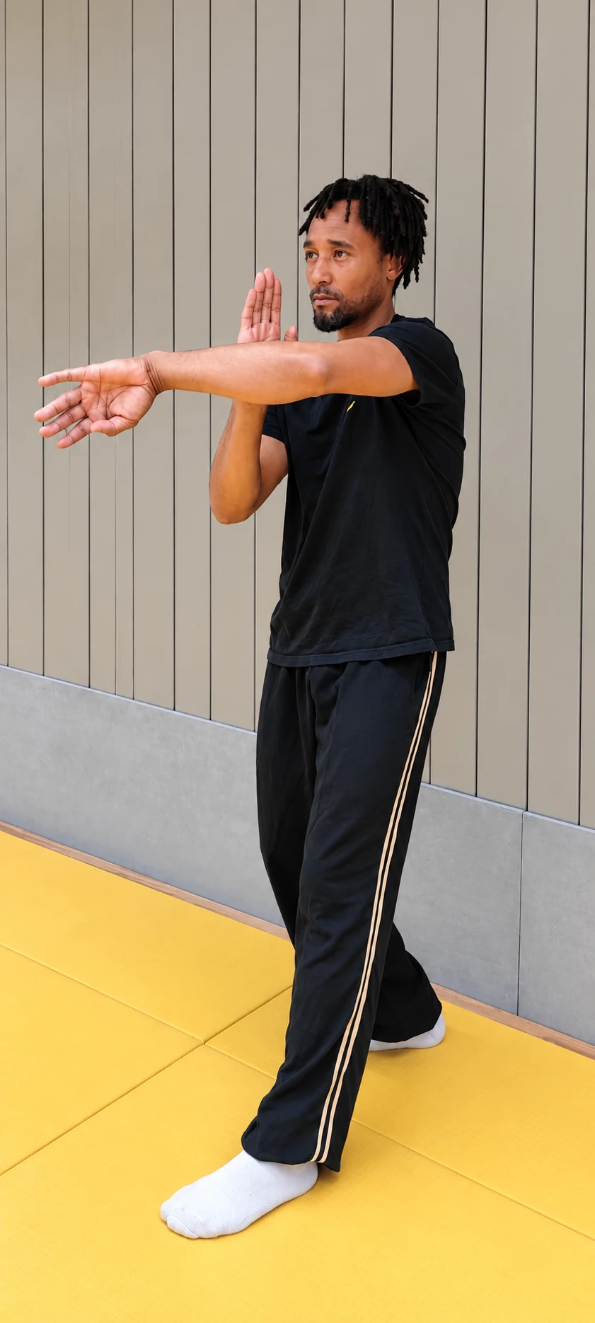 Sifu Manyrambona Yves en una posición de Wing Chun, con los brazos extendidos.