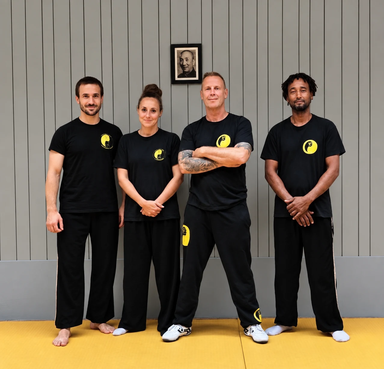 Sifu De Beil y los tres asistentes de la escuela reunidos para un retrato de grupo en la sala de Wing Chun.
